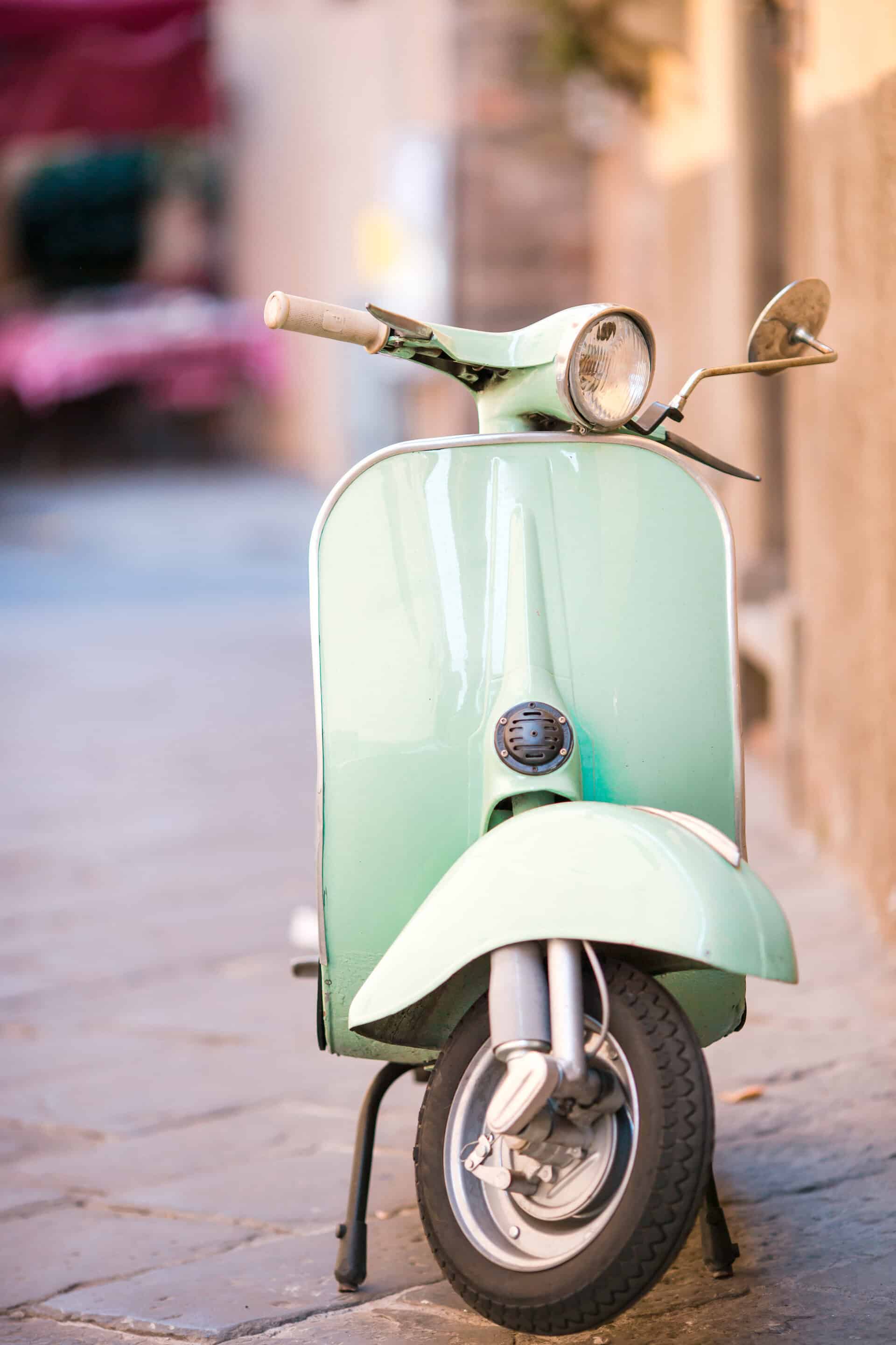 light blue scooter on the street of the old city. old classic european city elements